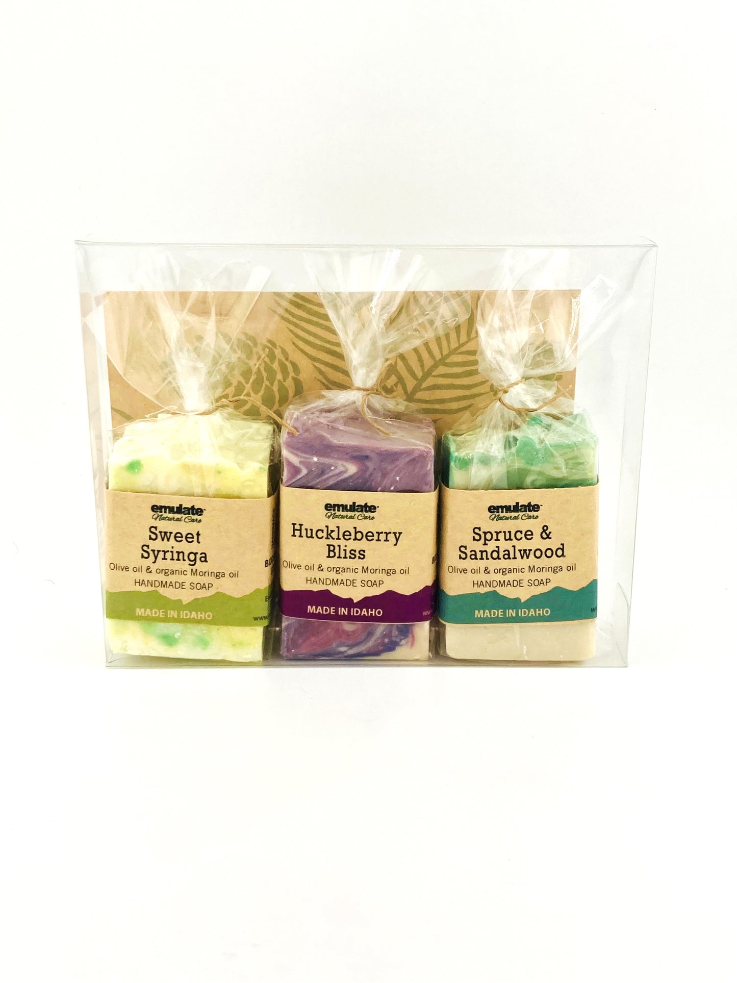 Three soaps in clear packaging with labels on a white background