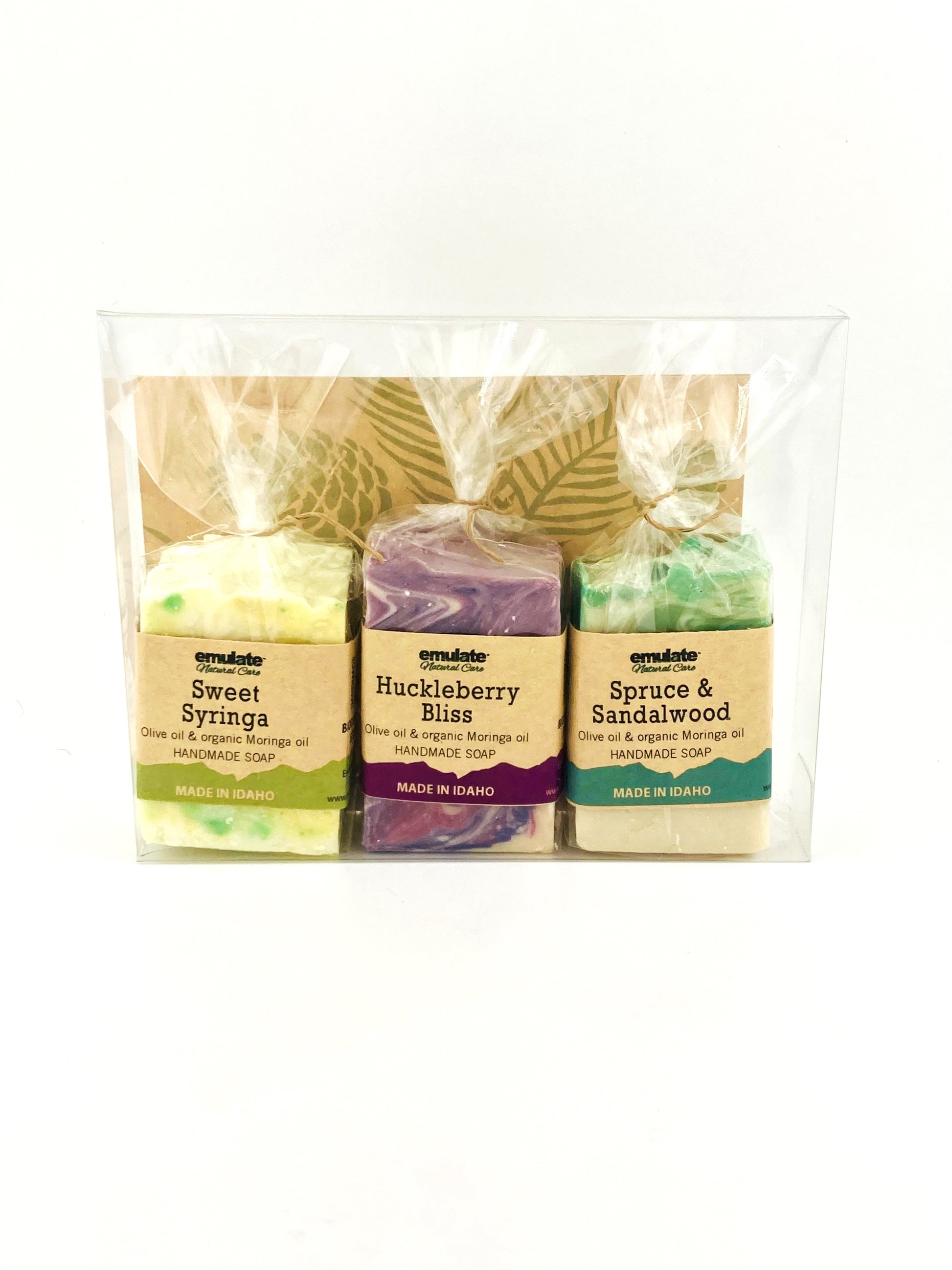 Three soaps in clear packaging with labels on a white background